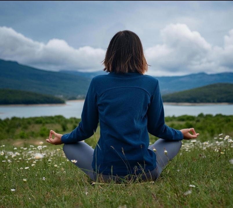 Persona seduta in meditazione durante un percorso di mindfulness